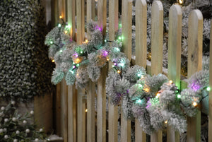 Christmas garland on garden fence wrapped in a set of these 360 pastel tree lights